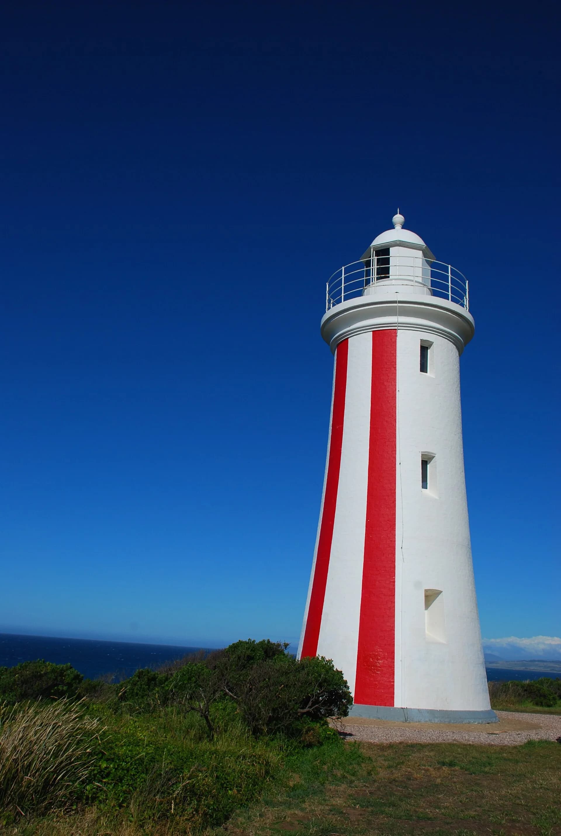 Striped Mersey Bluff lighthouse above the coast