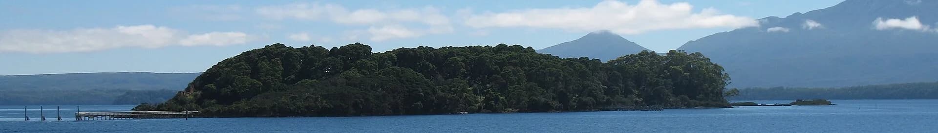 Sarah Island shoreline and low wooded terrain