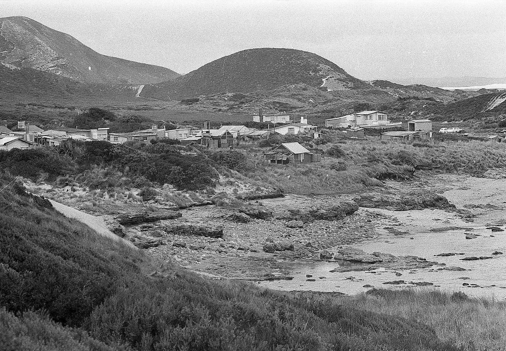 Trial Harbour settlement beside an exposed west-coast bay